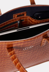 Interior photo of a Tan Croco Leather Slim Briefcase showing its main zippered compartment packed with a computer, internal multifunctional pockets and Lazaro silver ironwork.
