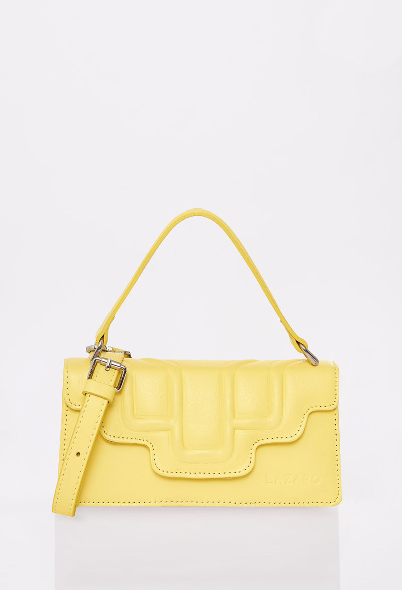 Front of a Yellow Leather Crossbody Flap Bag Hilda with a raised design flap, Lazaro logo and a removable and adjustable strap.