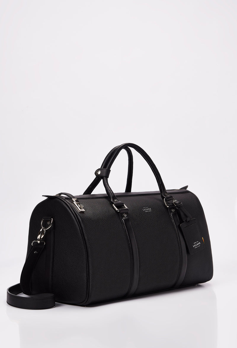 Side of a Black Leather Duffel Bag with lock closure, Lazaro logo, leather id, leather handles and a detachable shoulder strap.
