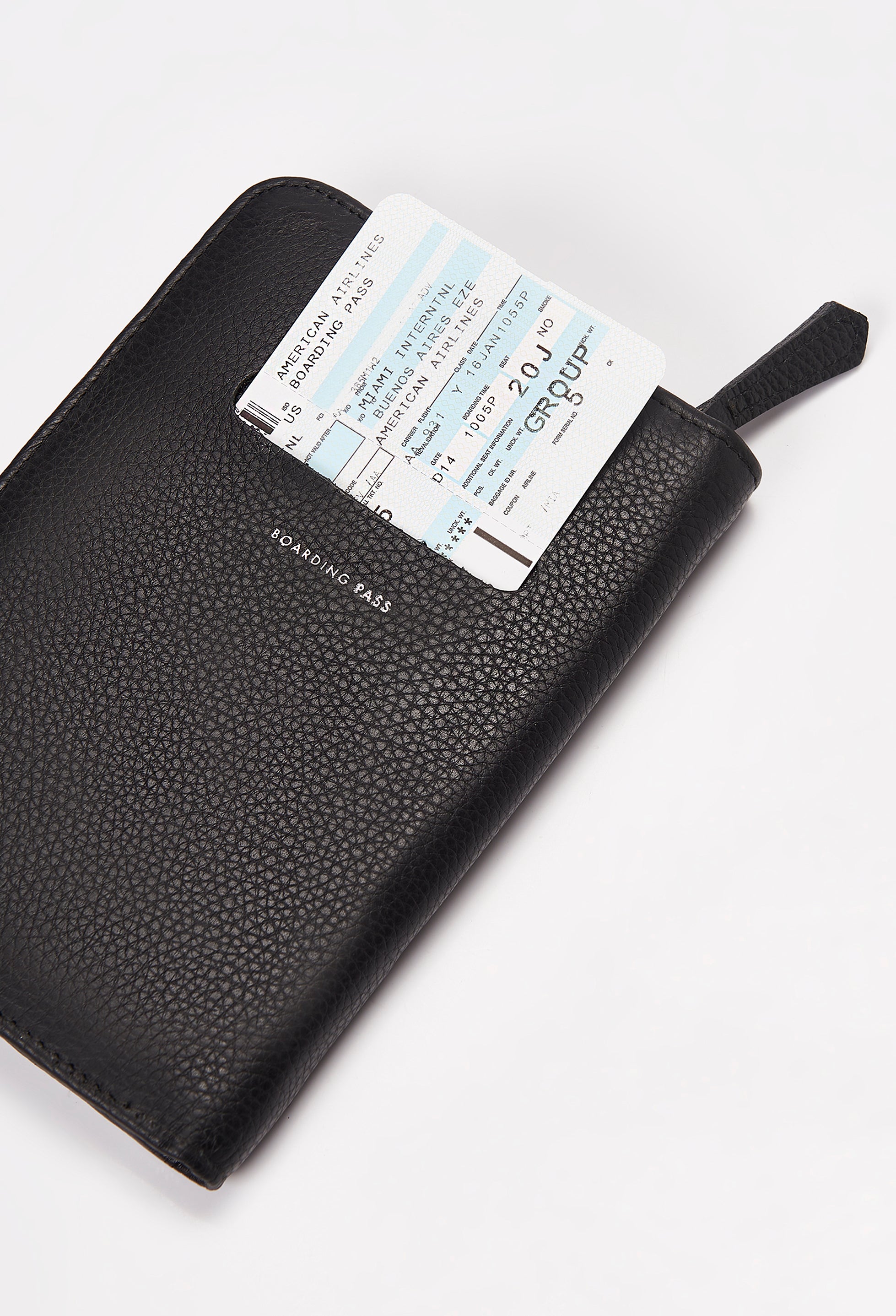 Rear of a Black Leather Passport Holder with a boarding pass on its labeled compartment.