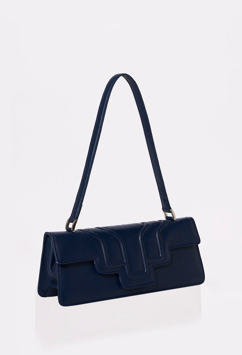 Side of a Blue Leather Shoulder Flap Bag Hilda with a raised design flap and Lazaro logo.