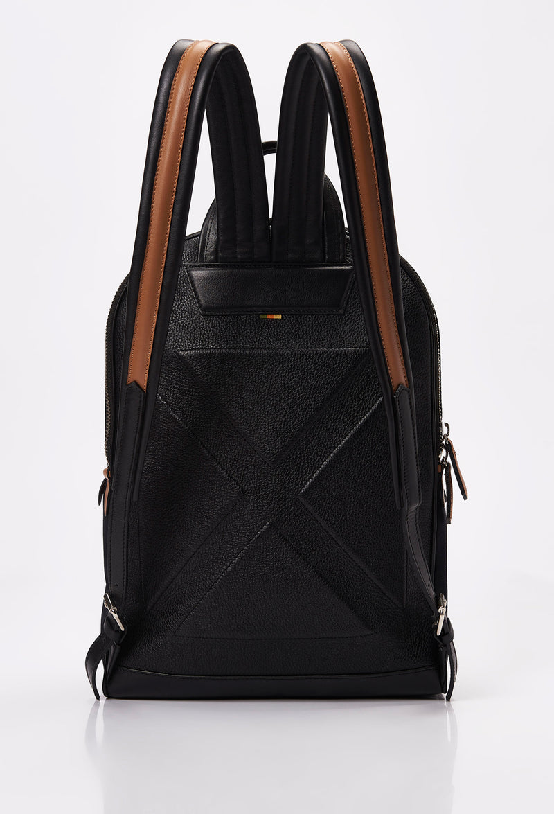 Rear of a Black Canvas and Leather Backpack ergonomically shaped with tan leather details and padded and adjustable straps.