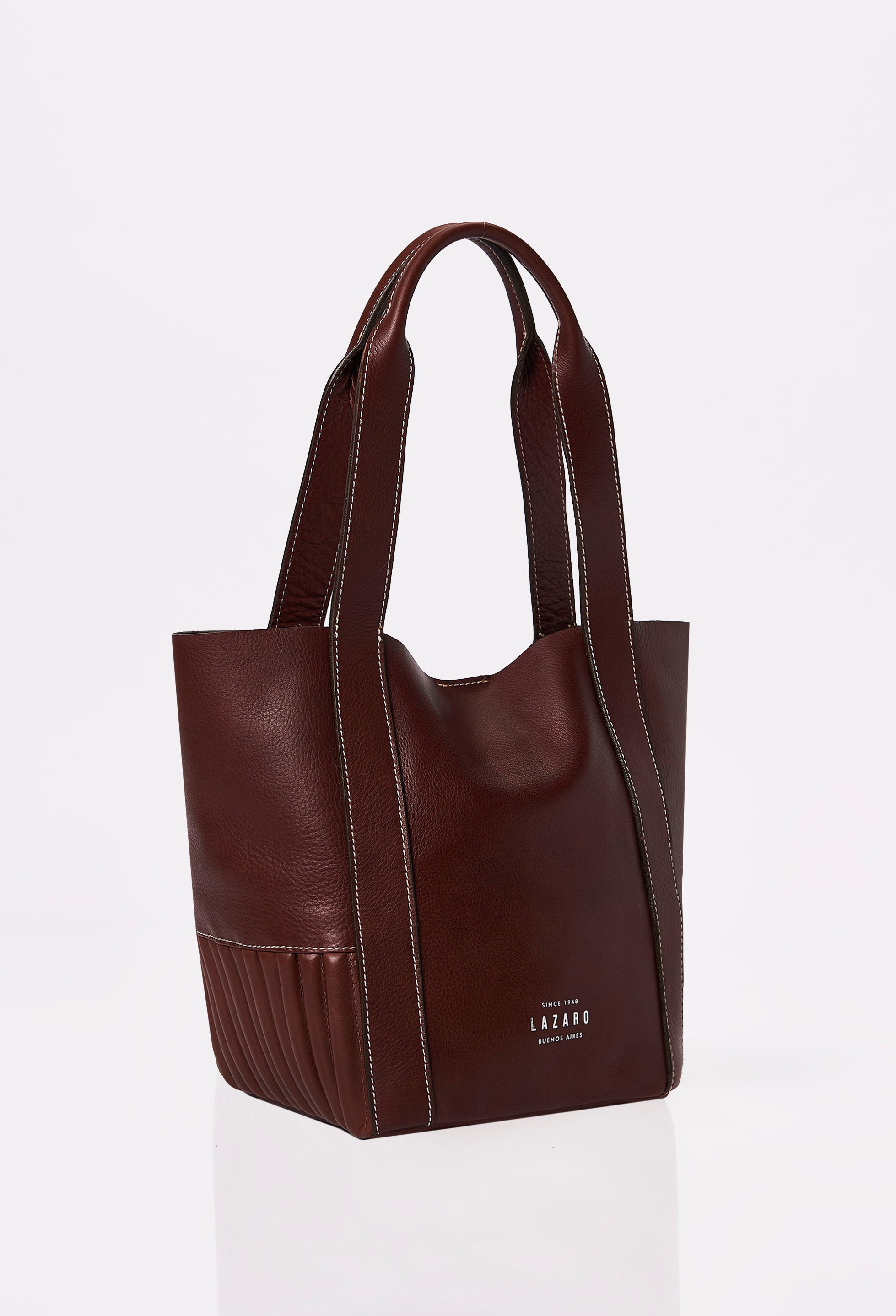 Side of a Coffee Leather Small Bucket Bag Ushuaia with Lazaro logo, needlework on the sides and contrast stitching highlights.