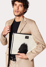 A model carries a sophisticated cowhide leather slim computer case, showcasing its sophisticated design. The bag features unique cowhide pattern, adding to its elegant appeal. The model confidently displays the bag's size and craftsmanship while exuding a sense of style and elegance.
