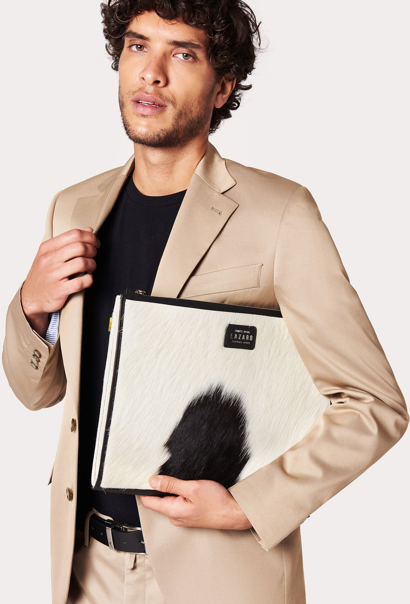 A model carries a sophisticated cowhide leather slim computer case, showcasing its sophisticated design. The bag features unique cowhide pattern, adding to its elegant appeal. The model confidently displays the bag's size and craftsmanship while exuding a sense of style and elegance.