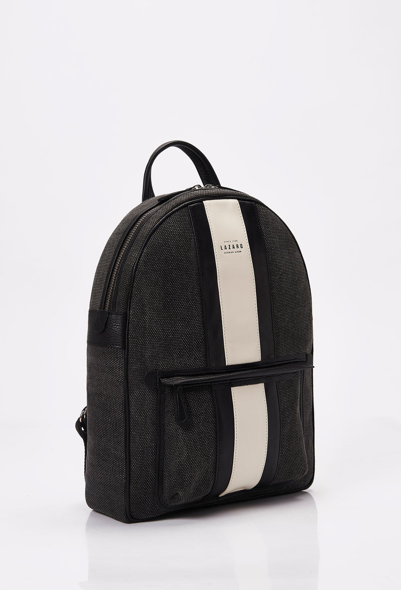 Side of a Lightweight Canvas Backpack made from distressed Panama canvas with Nappa leather trims in black and off white. It has a main zippered compartment, the Lazaro logo and a front zippered pocket.