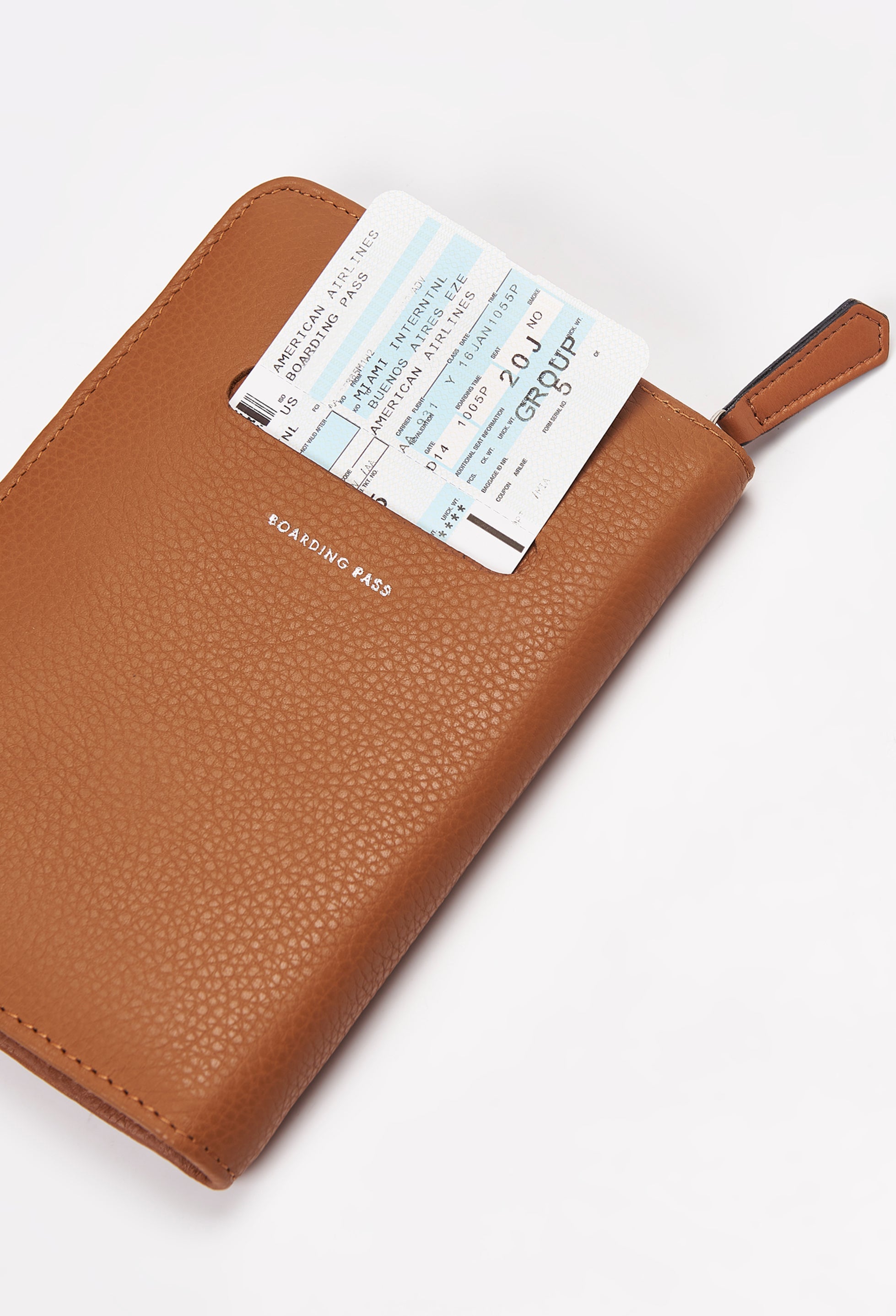 Rear of a Tan Leather Passport Holder with a boarding pass on its labeled compartment.