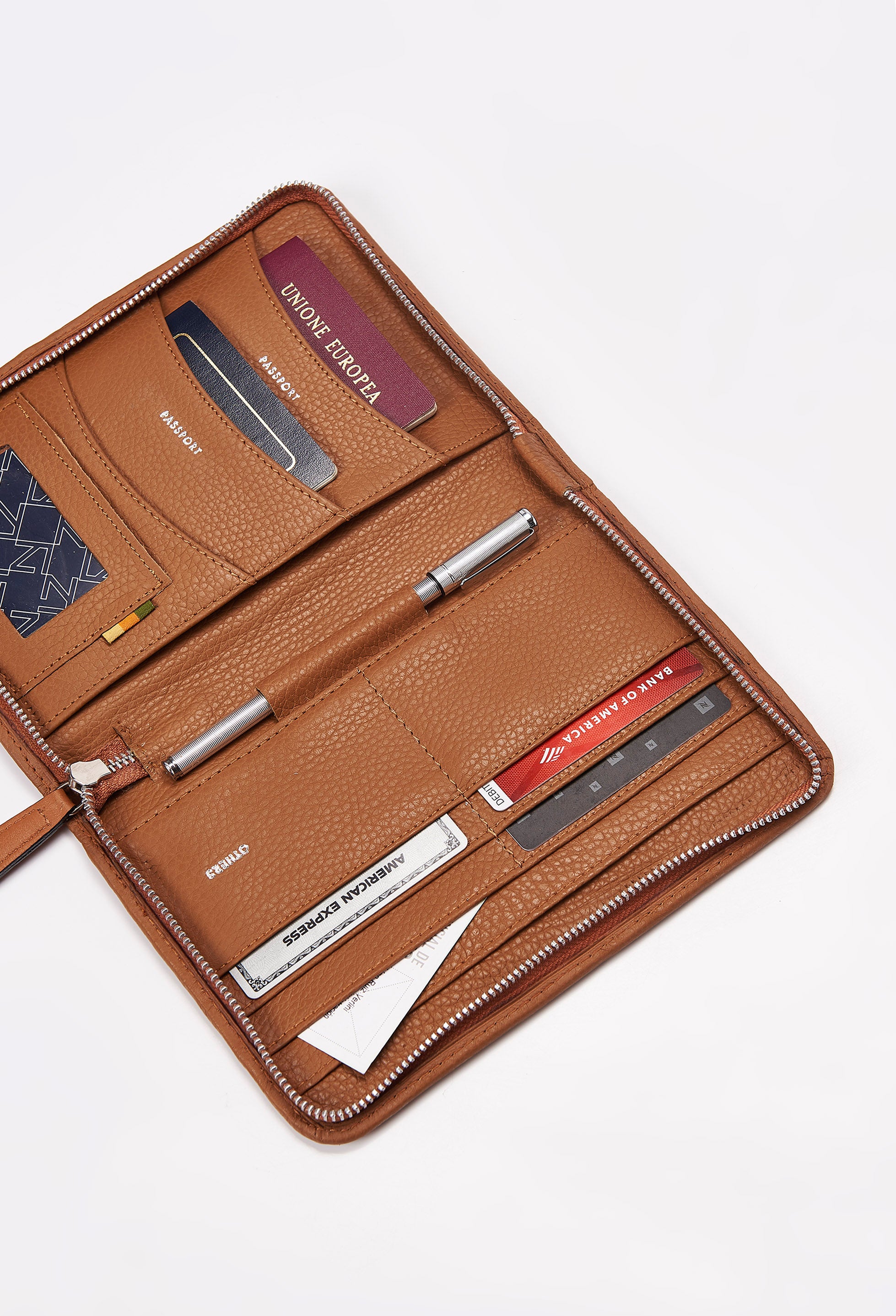 Interior of a Tan Leather Passport Holder featuring labeled compartments for multiple passports, credit cards, personal cards and a pen.