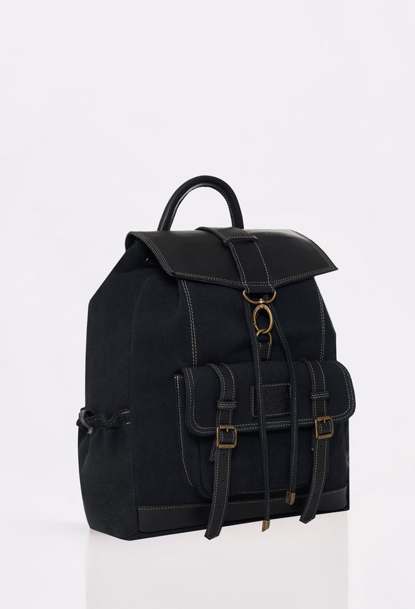Side of a Black Canvas Backpack with Lazaro logo, distressed antiqued bronze fittings and leather details.