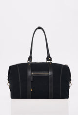 Rear of a Black Canvas Duffel Bag that shows a zippered pocket and leather handles.