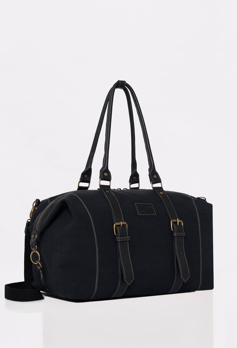 Side of a Black Canvas Duffel Bag with Lazaro logo, leather handles and a detachable shoulder strap.