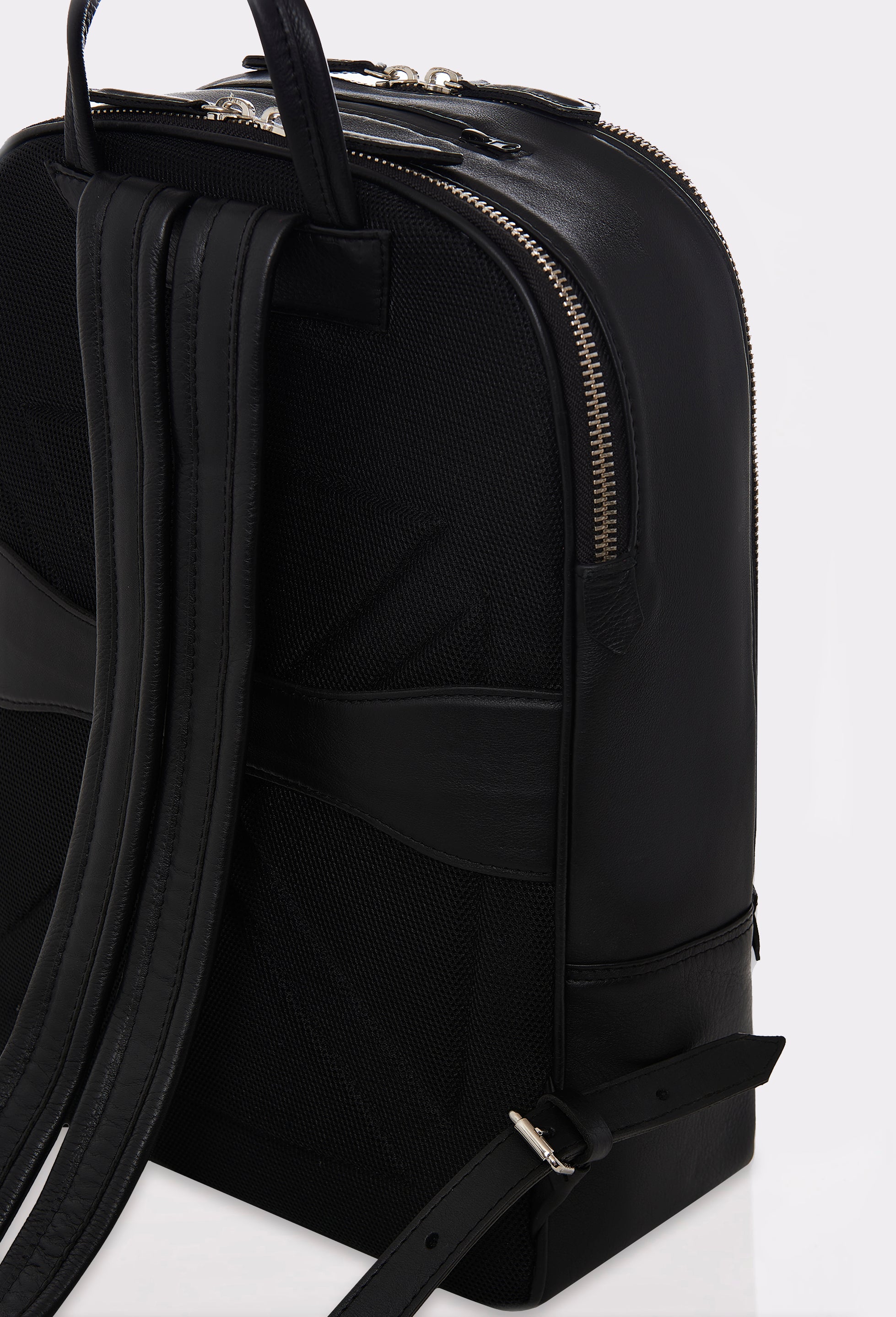 Partial photo of a Black Leather Backpack with two main compartments, an ergonomically shaped rear, made of durable textured mesh, with a leather integrated luggage holder and leather padded and adjustable straps.