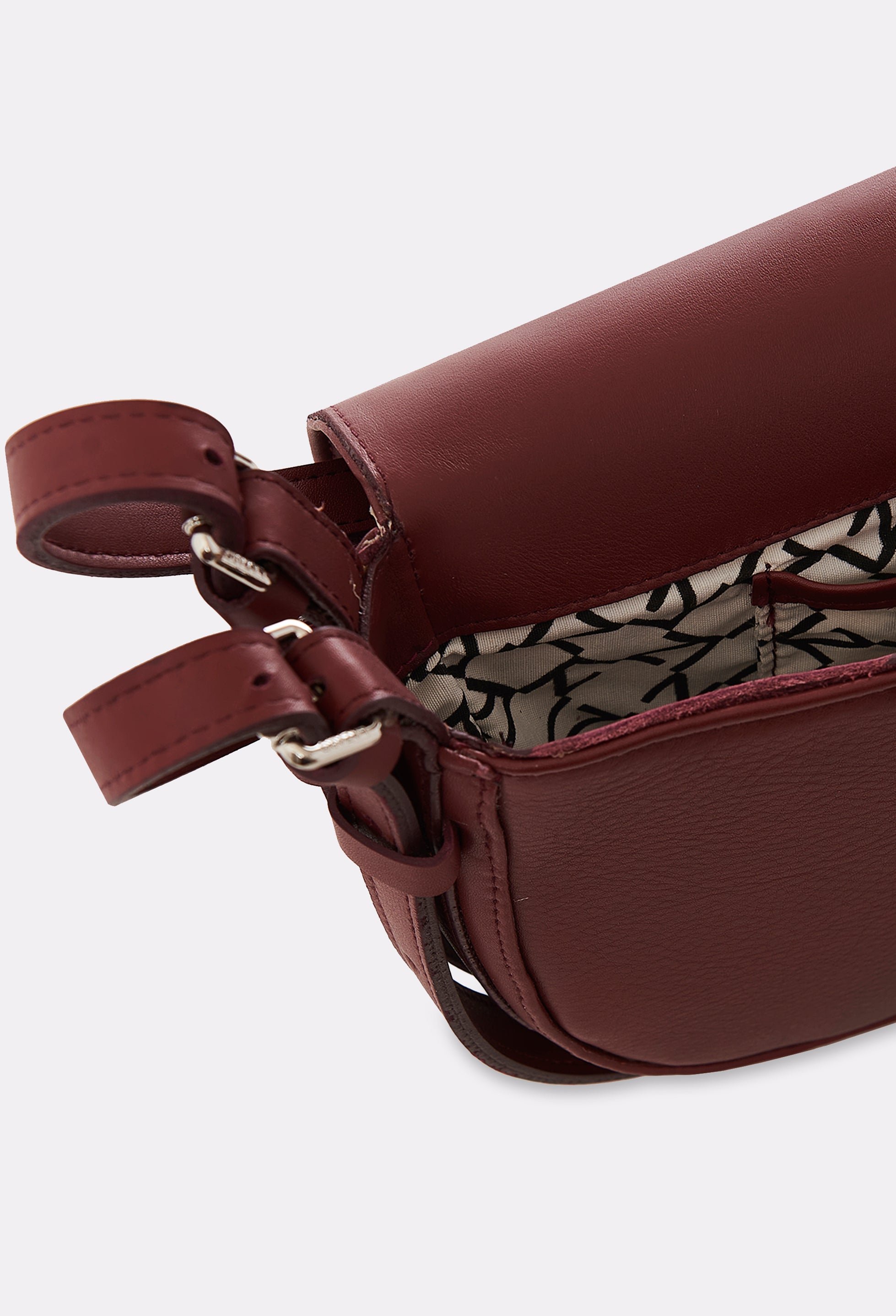 Partial photo of the interior of a Burgundy Leather Shoulder Bag Montana with a main compartment with Lazaro patterned lining and an internal pocket.