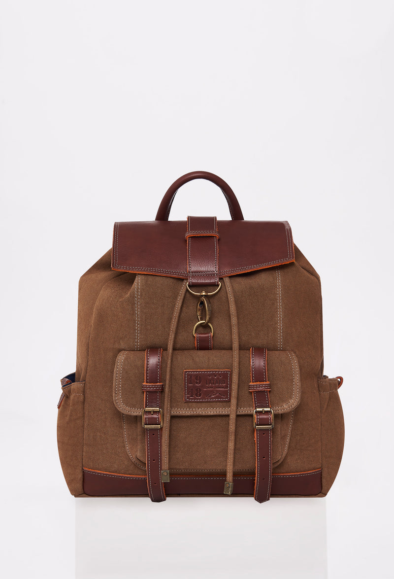 Front of a Coffee Canvas Backpack with Lazaro logo, distressed antiqued bronze fittings and leather details.