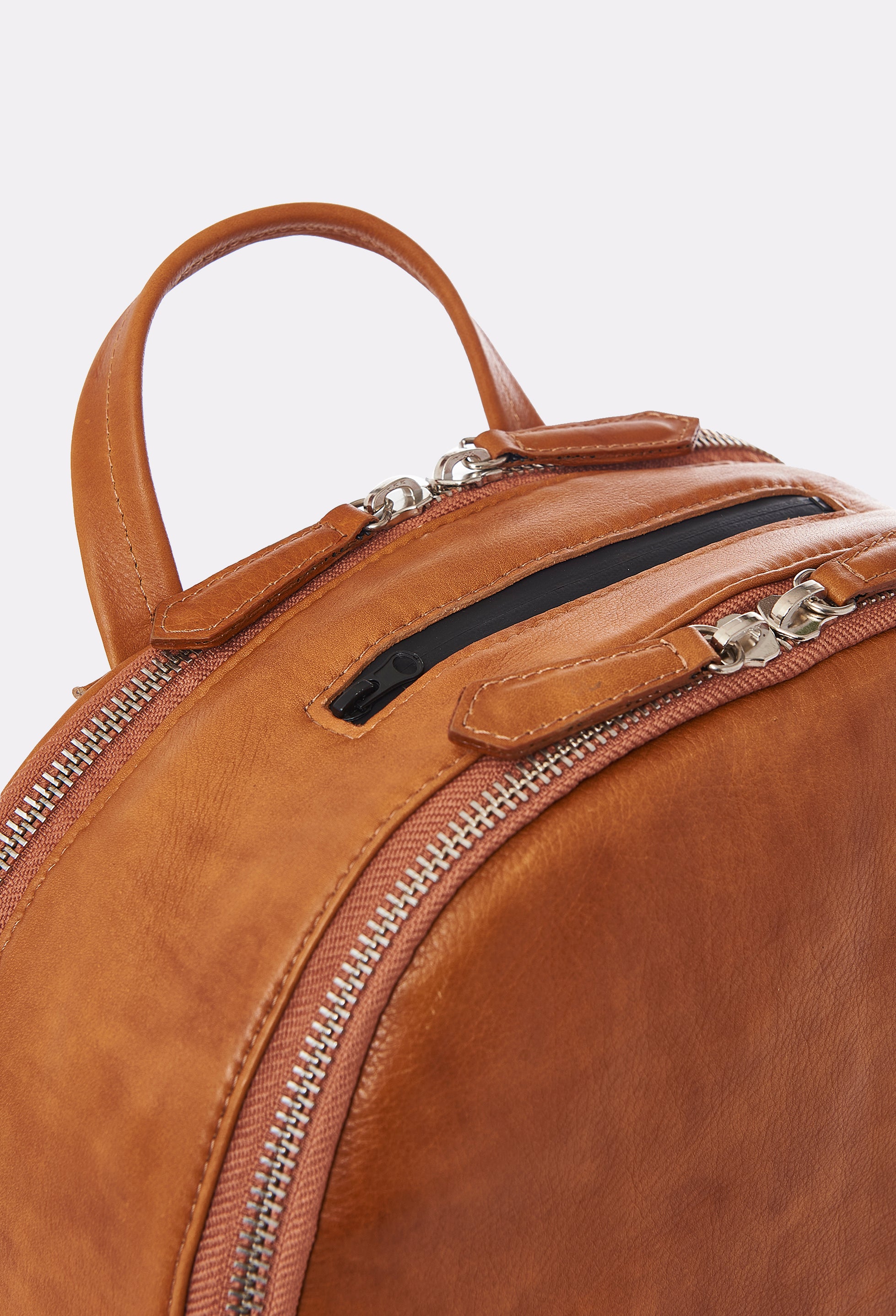 Partial photo of a Tan Leather Backpack that shows its two main zippered compartments and an external zippered pocket.