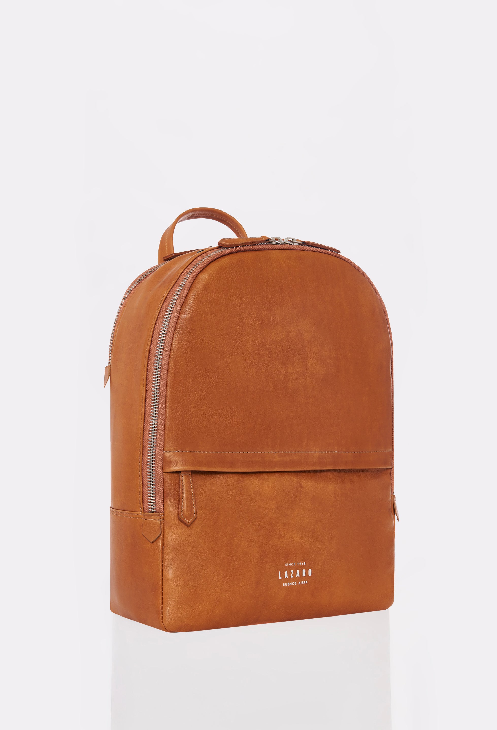 Side of a Tan Leather Backpack made out of Argentinian Bridge Leather with 2 main compartments and 2 external zippered pockets.