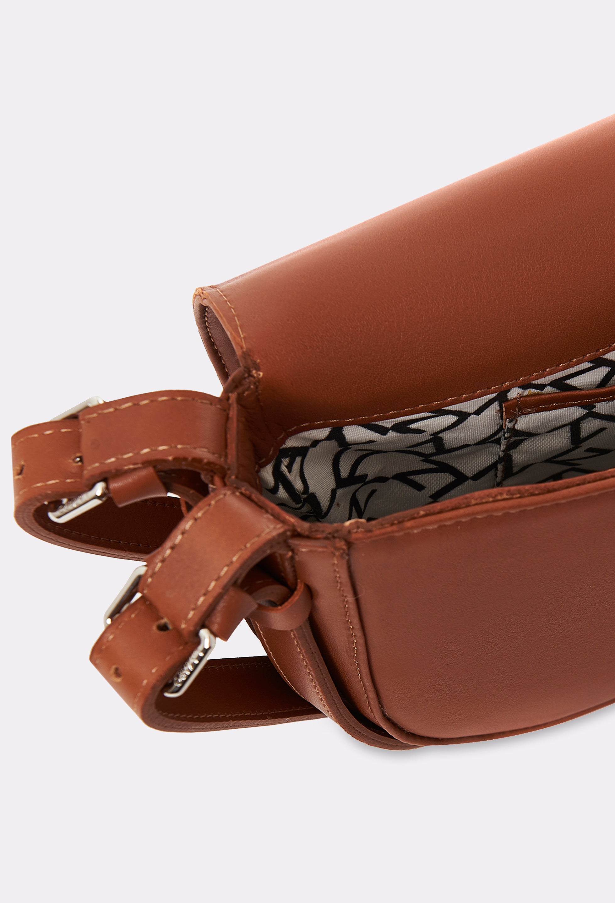 Partial photo of the interior of a Tan Leather Shoulder Bag Montana with a main compartment with Lazaro patterned lining and an internal pocket.