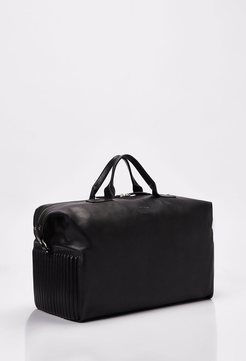 Side of a Black Leather Duffel Bag with side needlework, Lazaro logo and a main zippered compartment.