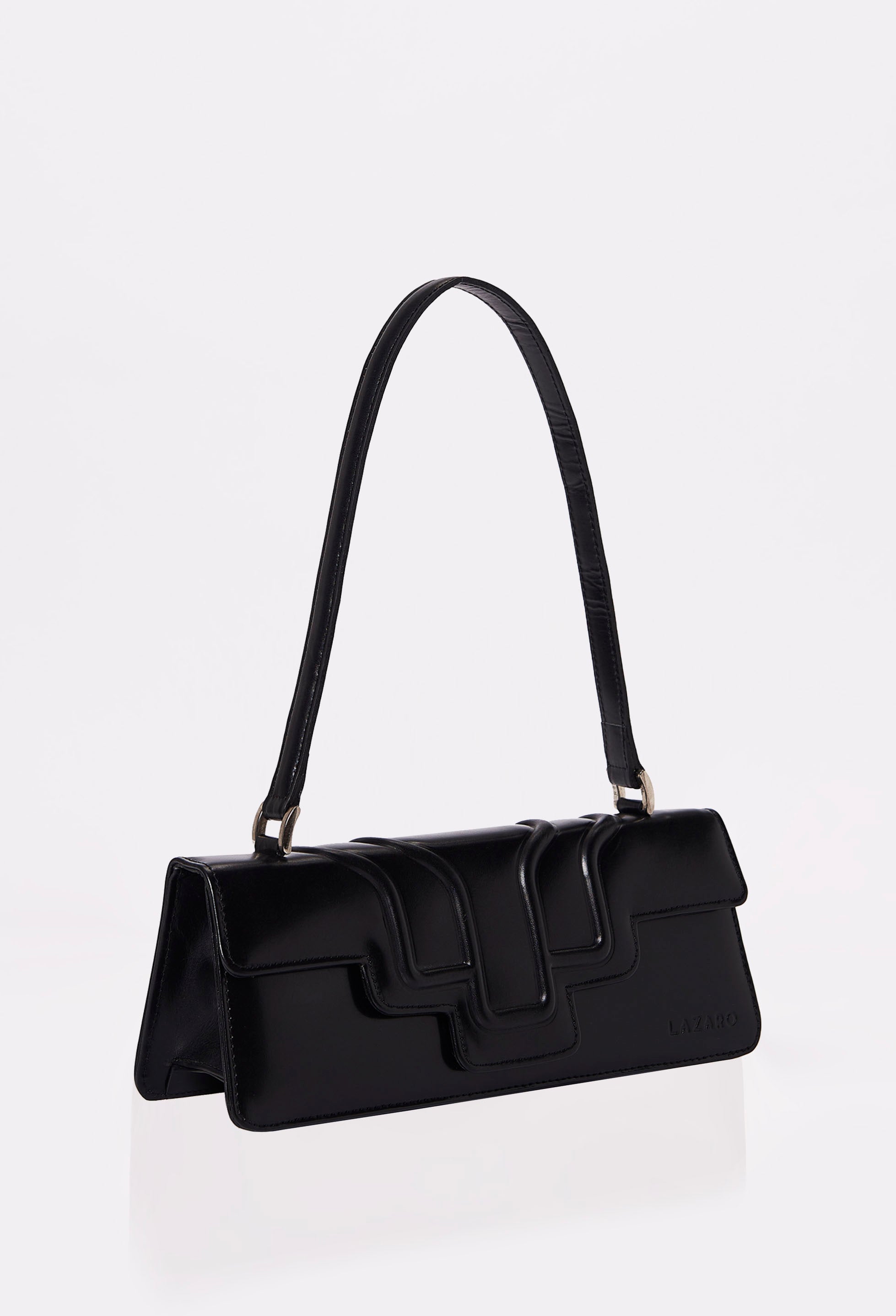 Side of a Black Leather Shoulder Flap Bag Hilda with a raised design flap and Lazaro logo.