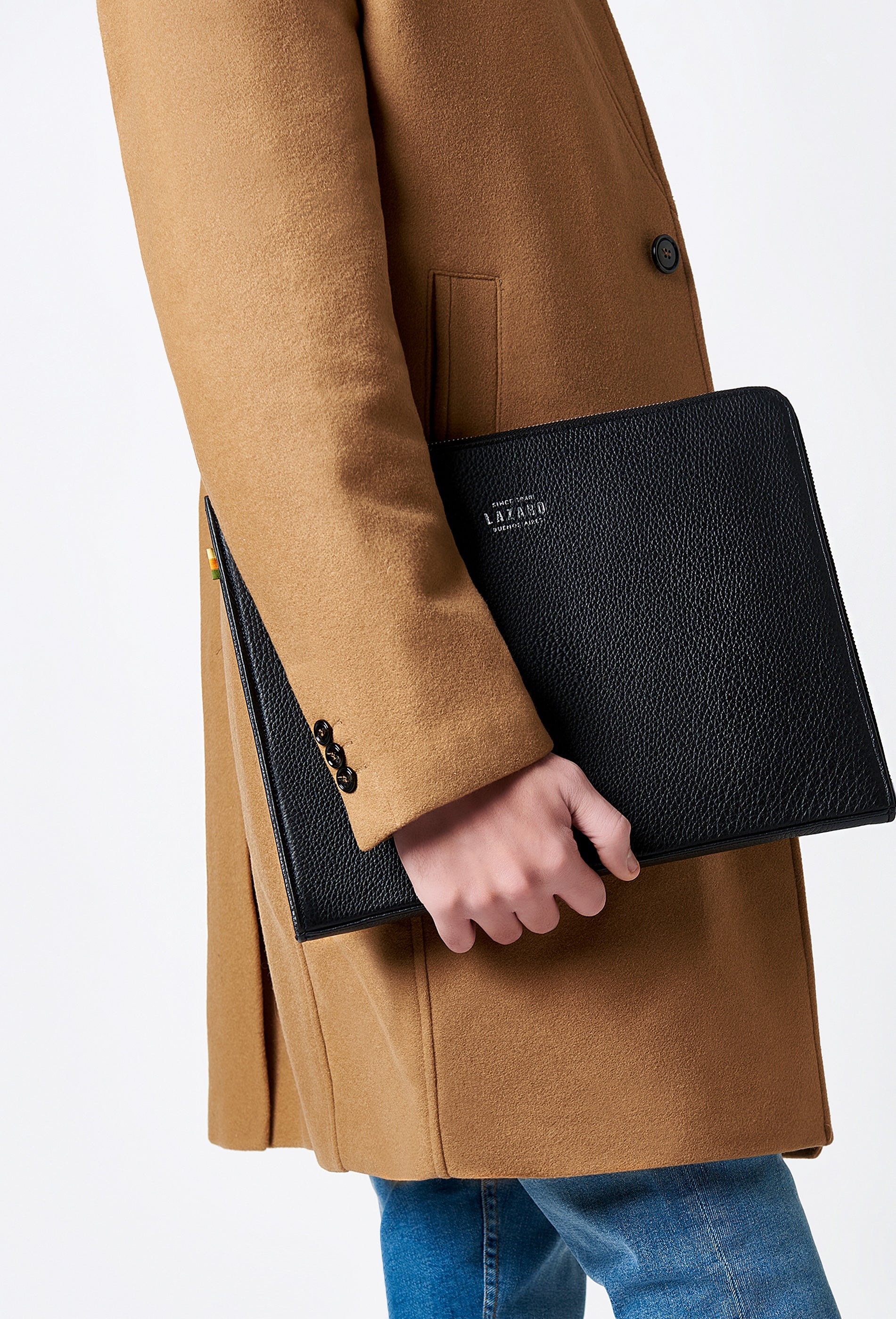 A model carries a sophisticated black leather slim computer case, showcasing its sophisticated design. The bag features internal pockets and compartments, adding to its elegant appeal. The model confidently displays the bag's size and craftsmanship while exuding a sense of style and elegance.