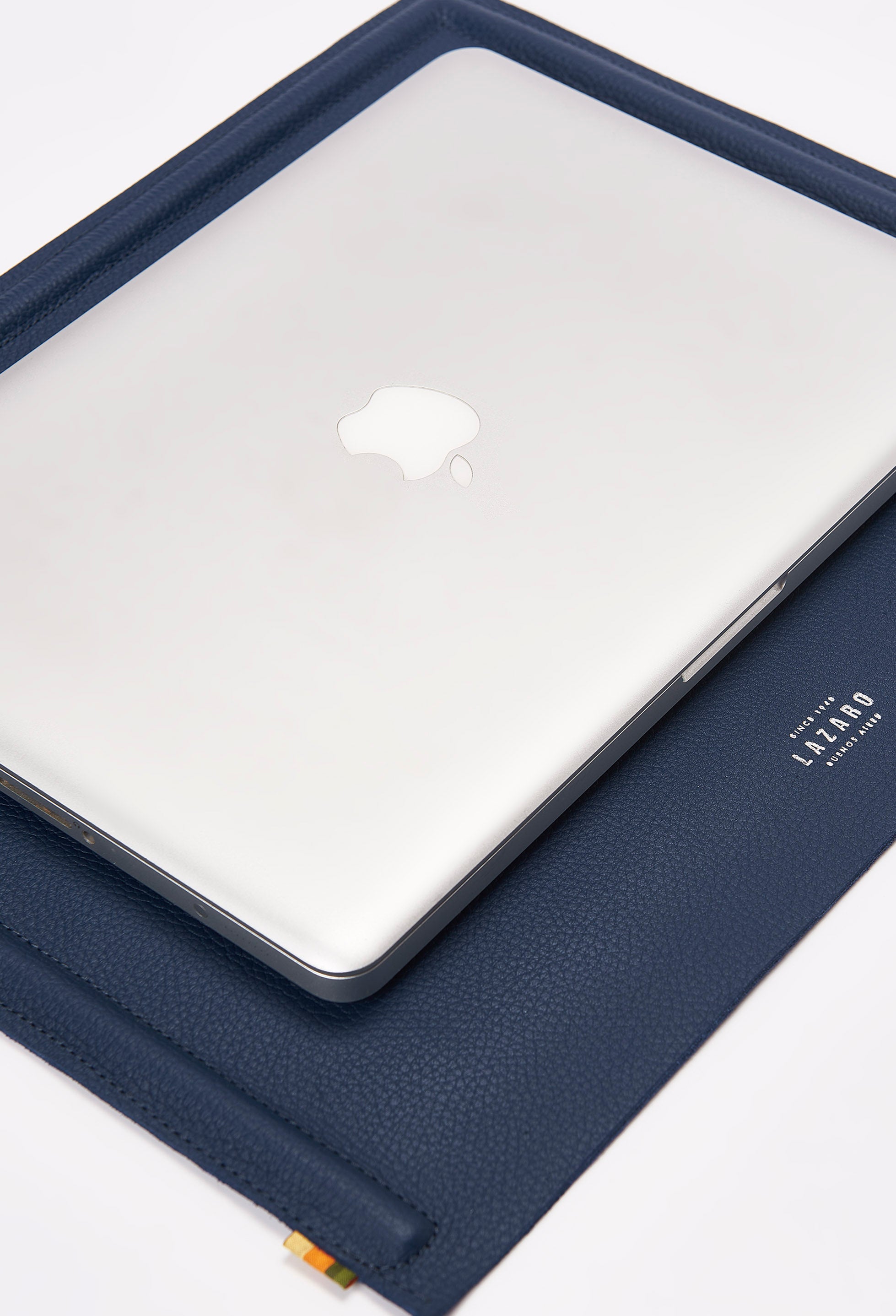 A Blue Leather Minimalist Desk Mat with embossed Lazaro logo and a computer on it.