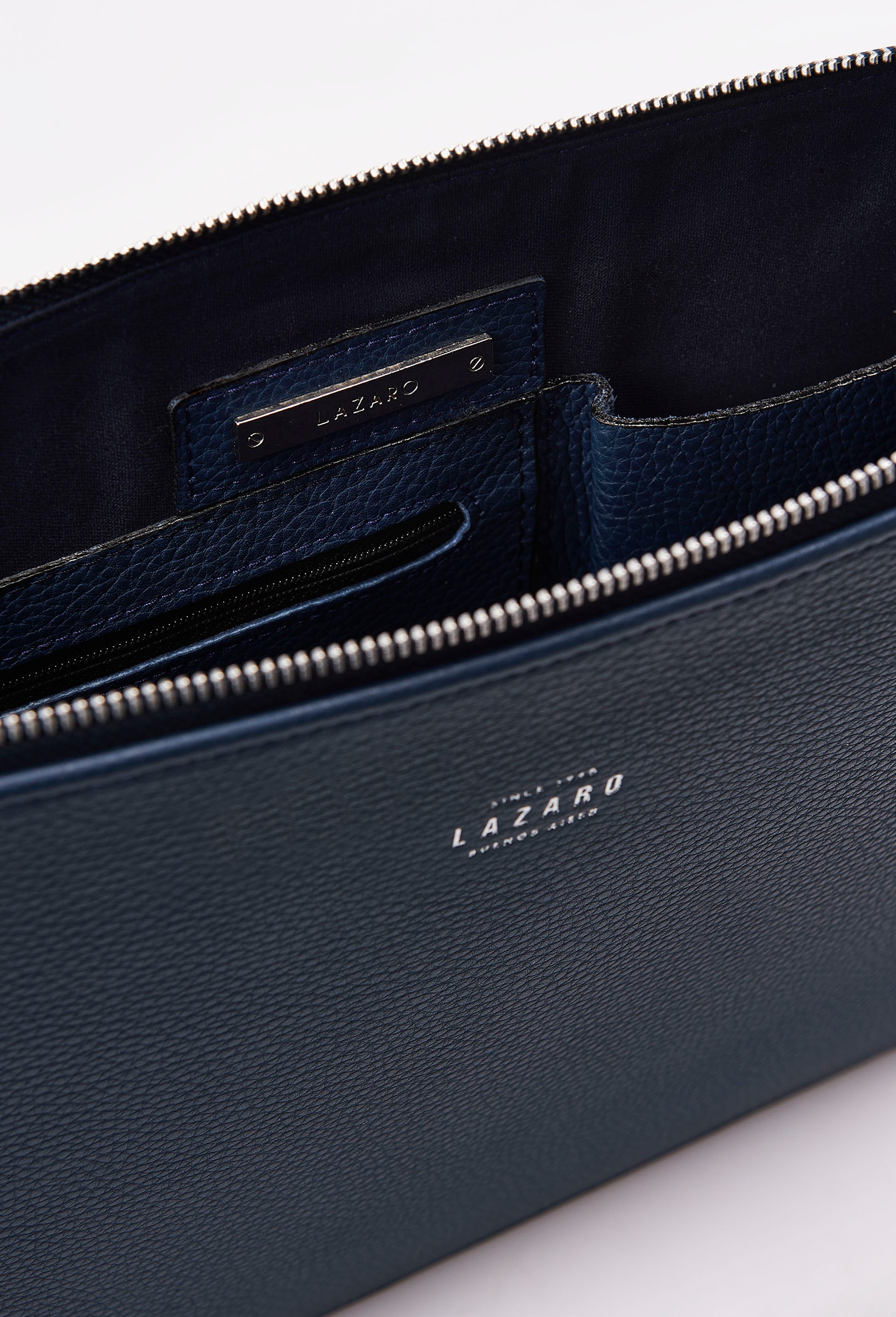 Partial photo of a Blue Leather Slim Computer Case showing its main zippered compartment, internal multifunctional pockets and Lazaro silver ironwork.