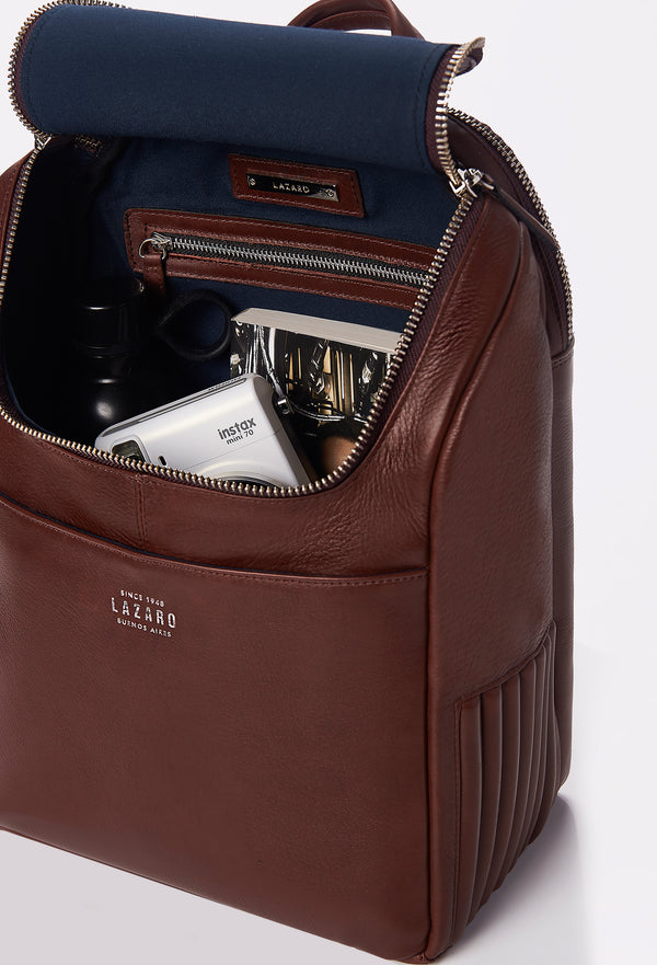 Interior of a Coffee Leather Backpack that shows a zippered main compartment, the side needlework, a front pocket and an internal zippered pocket.