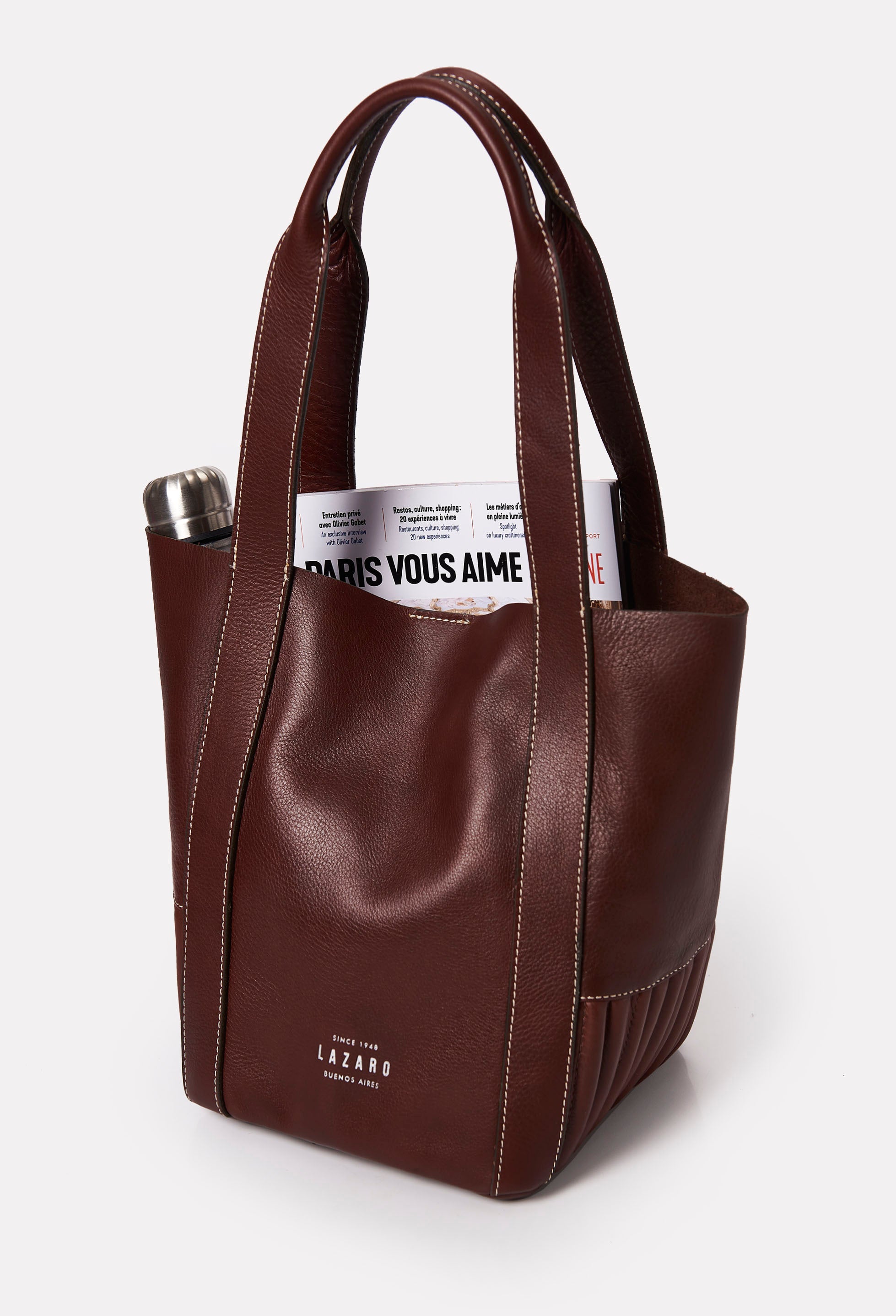 Interior of a Coffee Leather Mini Bucket Bag Ushuaia that shows the bag fits a magazine and a water bottle.