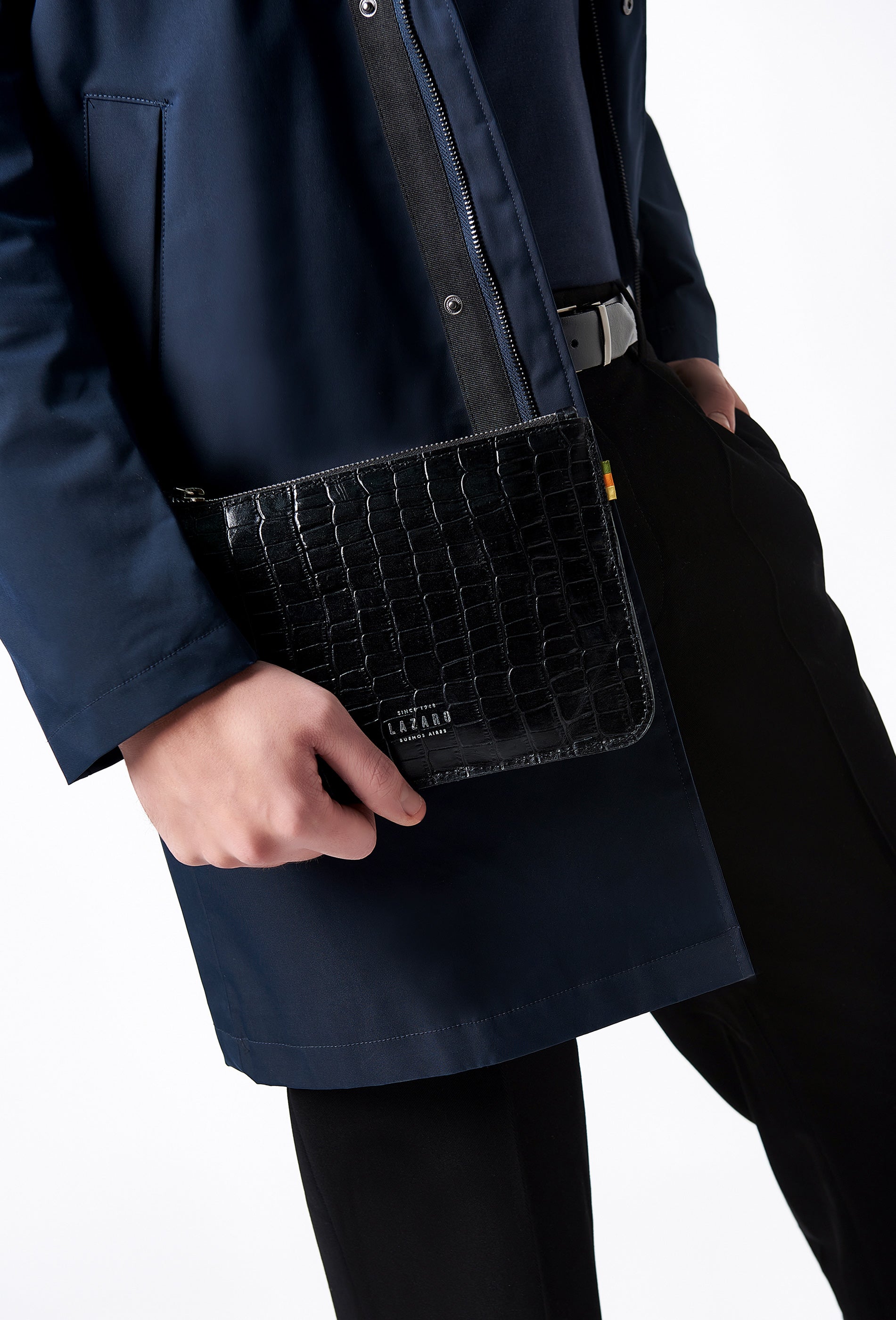 A model carries a sophisticated black croco leather zipper pouch, showcasing its sophisticated design. The model confidently displays the bag's size and craftsmanship while exuding a sense of style and elegance.