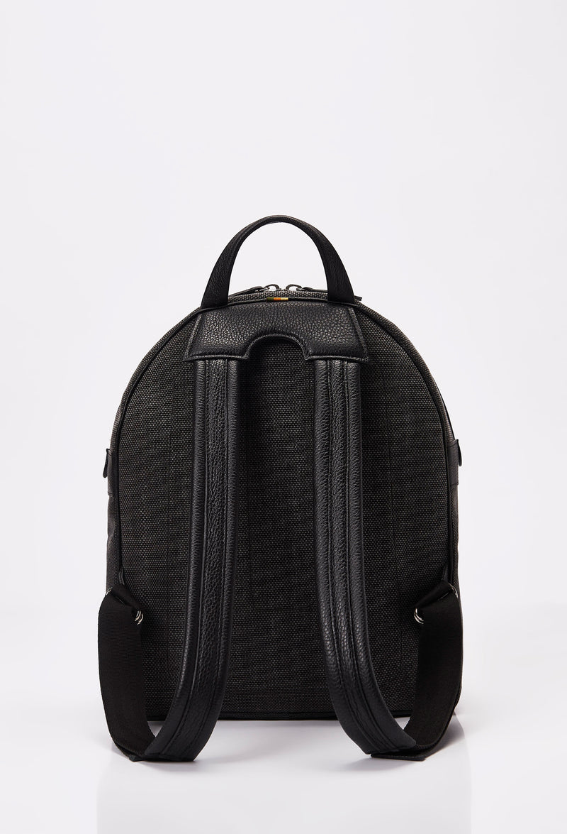 Rear of a backpack in distressed Panama canvas, ergonomically shaped and featuring leather padded and adjustable straps.