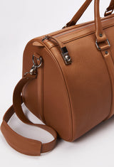 Partial photo of a Tan Leather Duffel Bag with lock closure, a zippered main compartment, and a detachable leather shoulder strap.