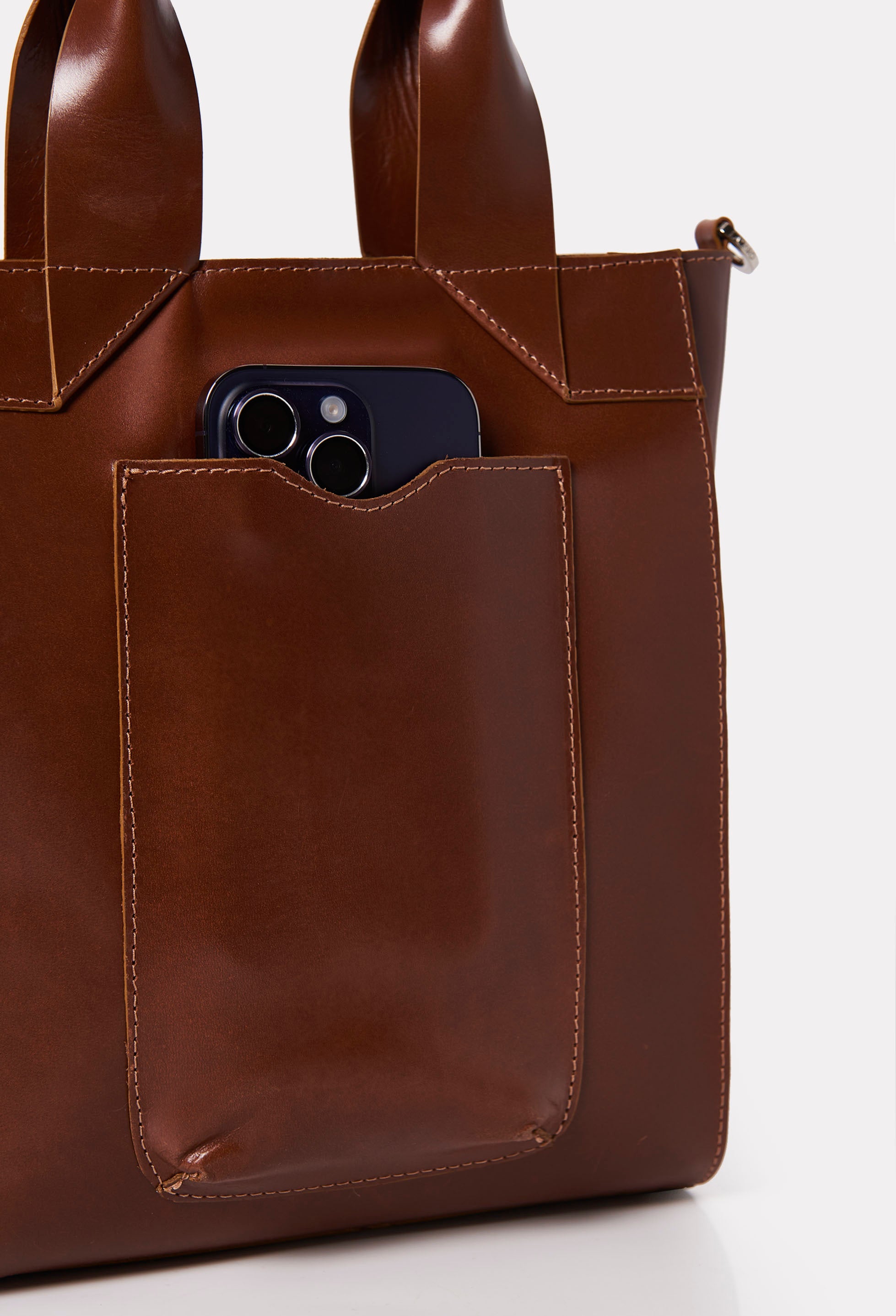 Partial photo of a Tan Leather Mini Tote Bag Lambro with an external cell phone holder pocket.
