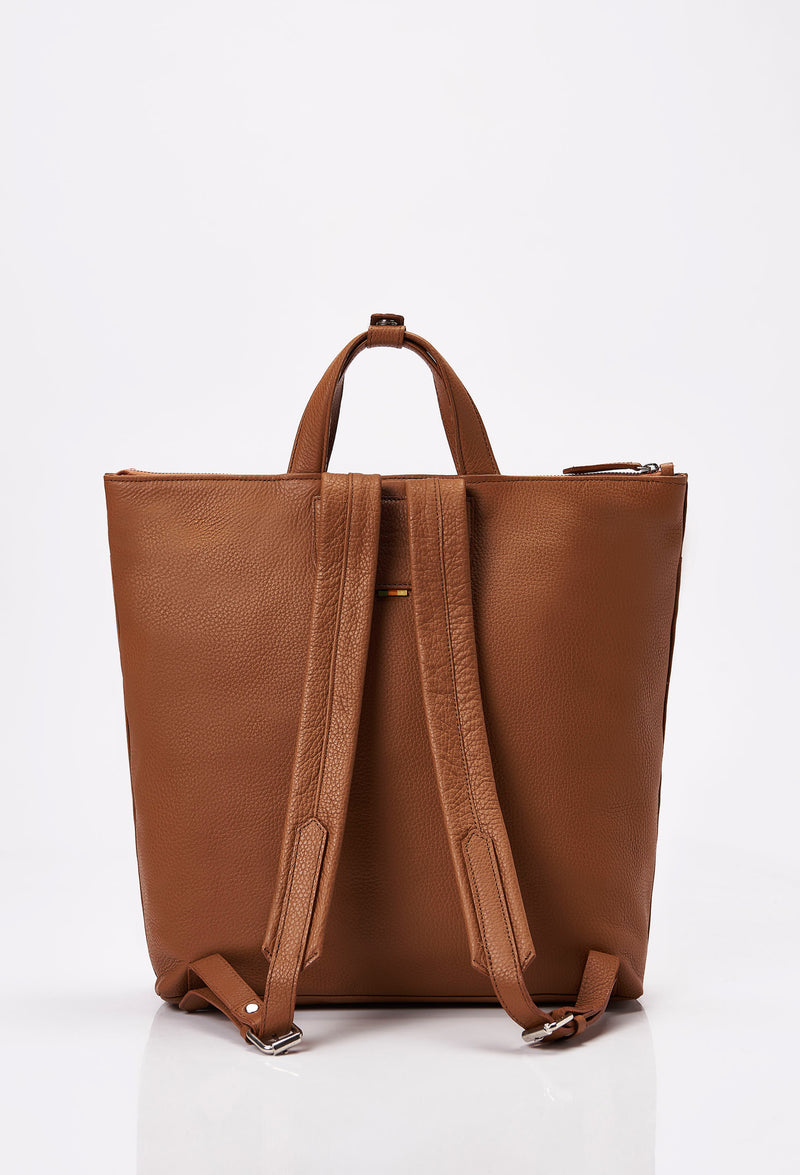 Rear of a Tan Leather Tote Backpack with leather padded and adjustable straps.