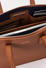 Interior photo of a Tan Leather Slim Briefcase showing its main zippered compartment packed with a computer, internal multifunctional pockets and Lazaro silver ironwork.